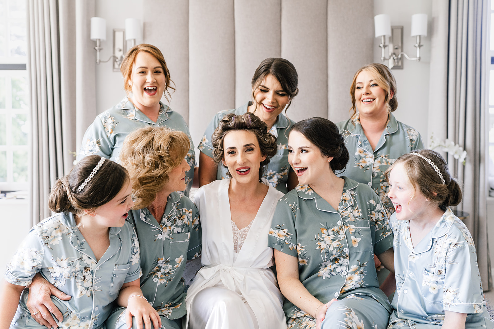 Bridal prep, bridesmaids laughing on the bed