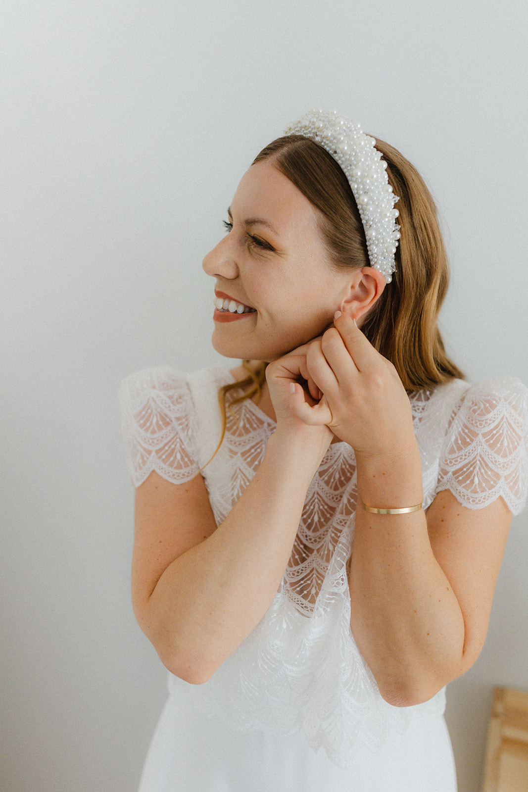 Bride-putting-Earrings-on-dressing-up