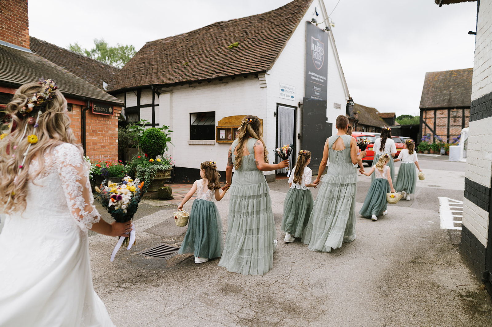 The bride and her bridesmaids crossing the car park at Hundred House Hotel to go to the wedding ceremony