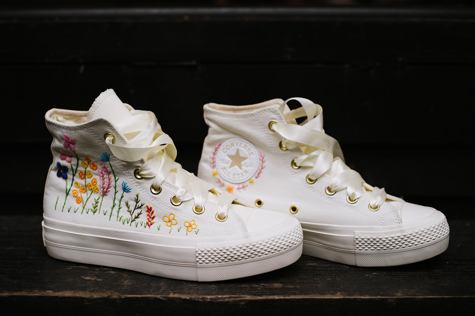 The bride's embroidered white wedding shoes were converse with colourful flowers stitched on the sides.