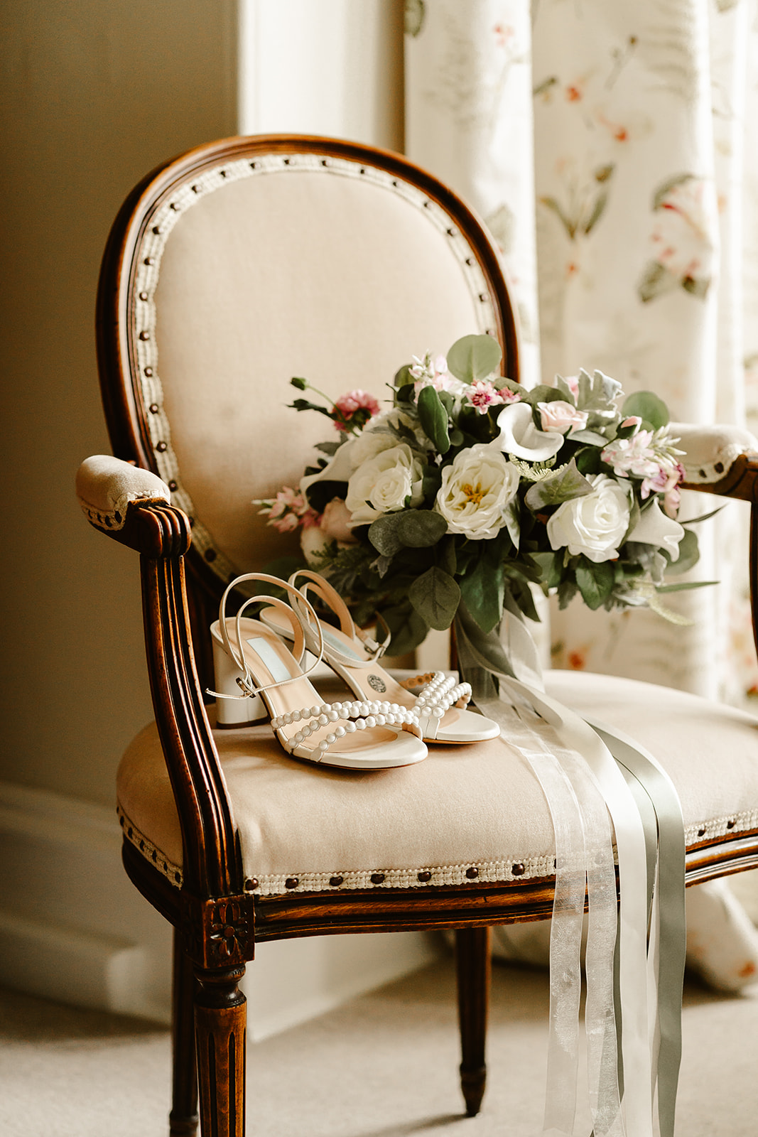 Image of a bridal bouquet on a chair with some gorgeous shoes