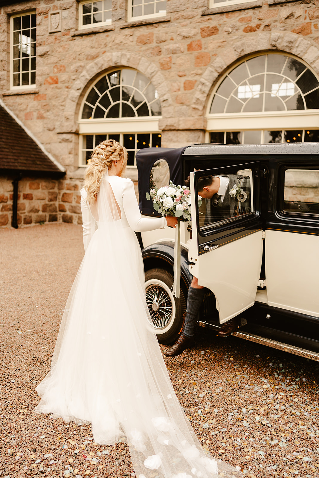 Image of a Bride and Groom standing outside a Vintage Car, outside The Coos Cathedral