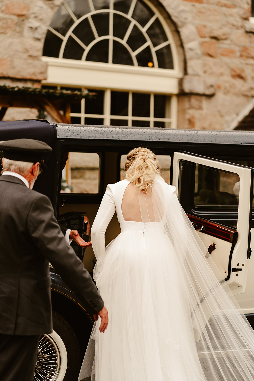 Image of a Bride and Groom standing outside a Vintage Car