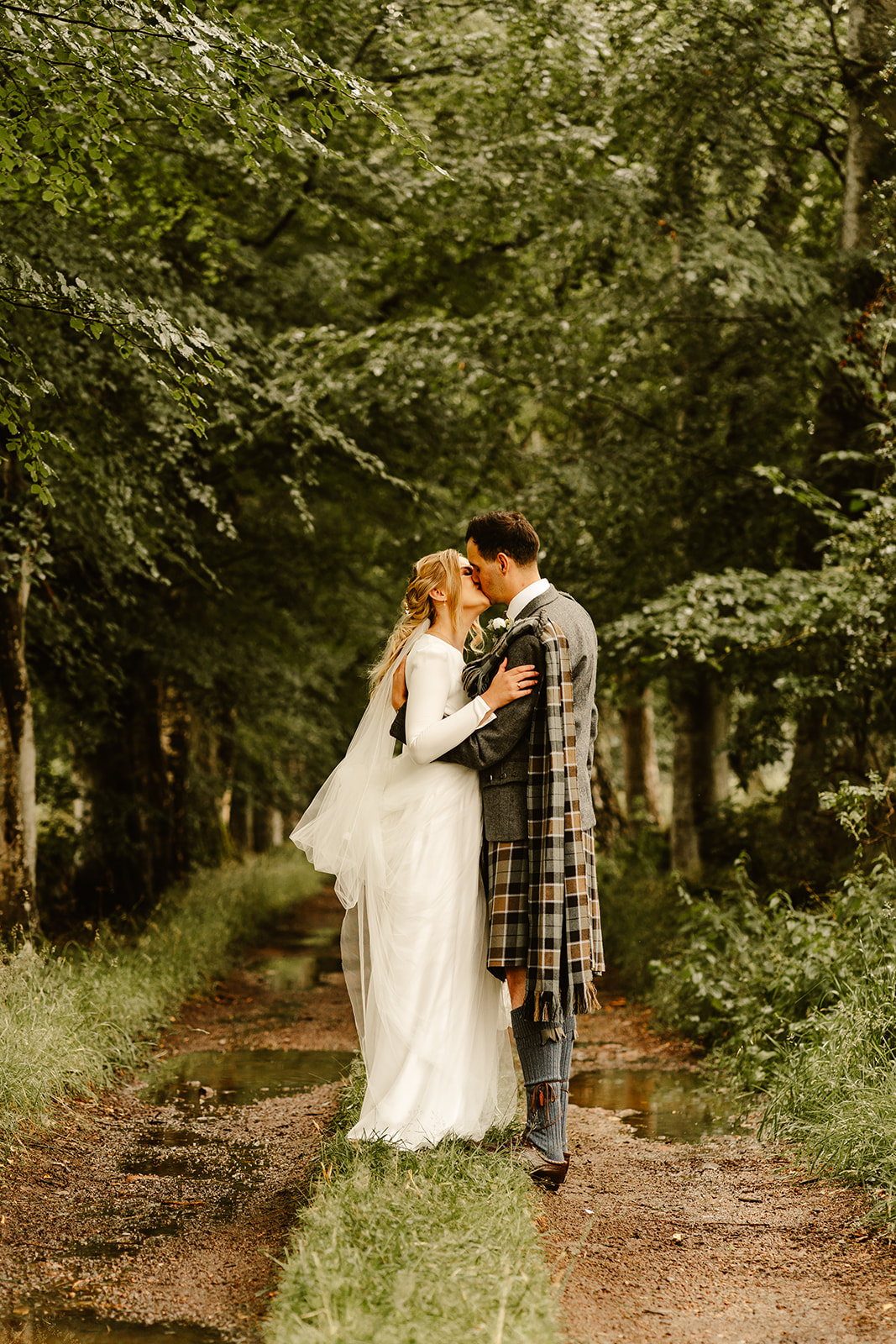 Bride and groom sharing a kiss in the woodland