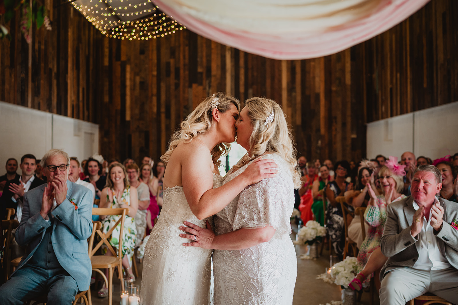 A female same sex couple share their first kiss after getting married