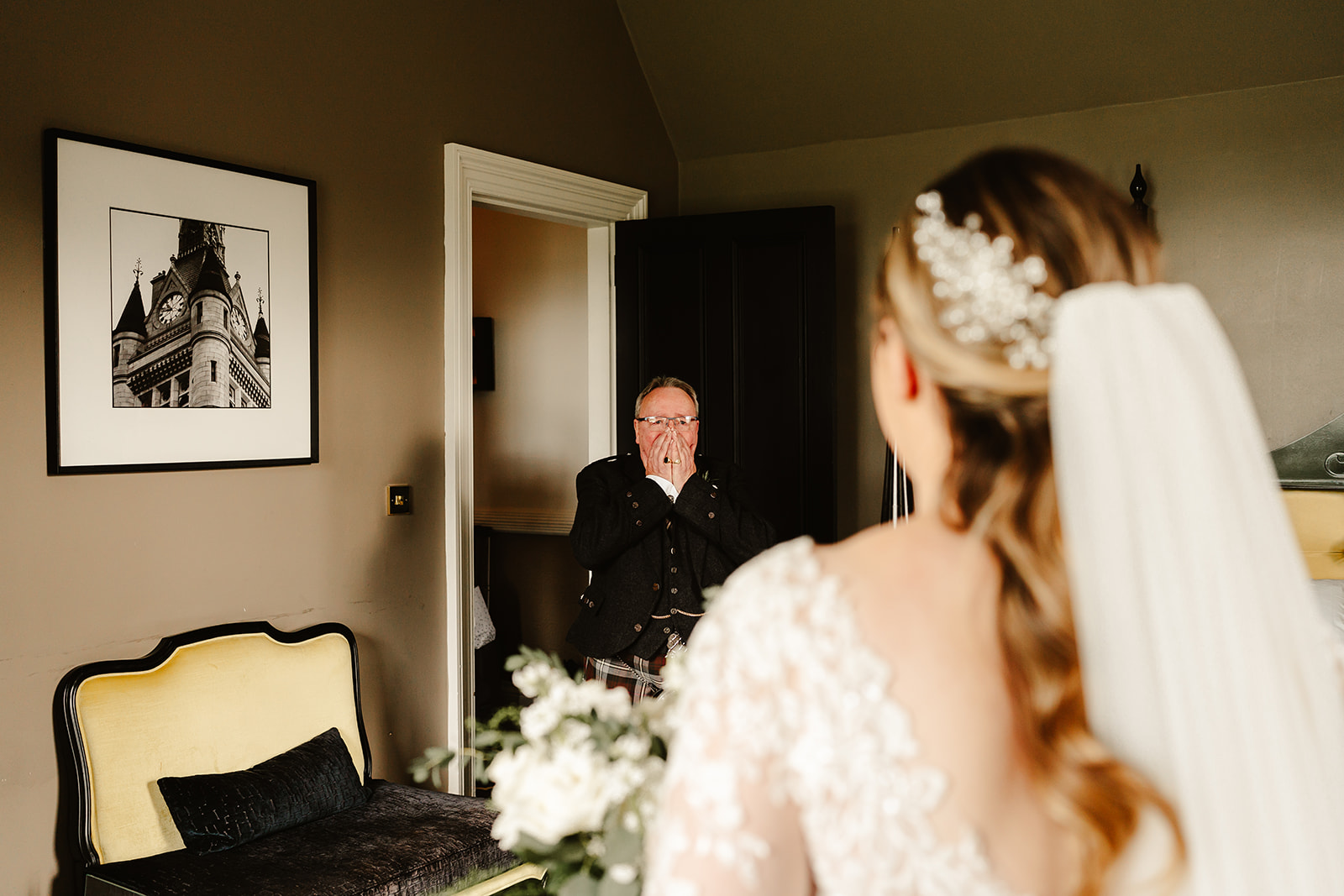 Father of the bride seeing his daughter in her wedding dress for the first time
