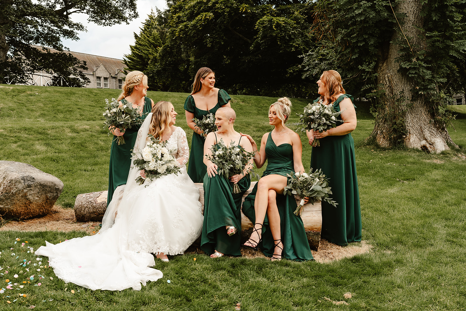Bride sitting with her bridesmaids wearing green dresses