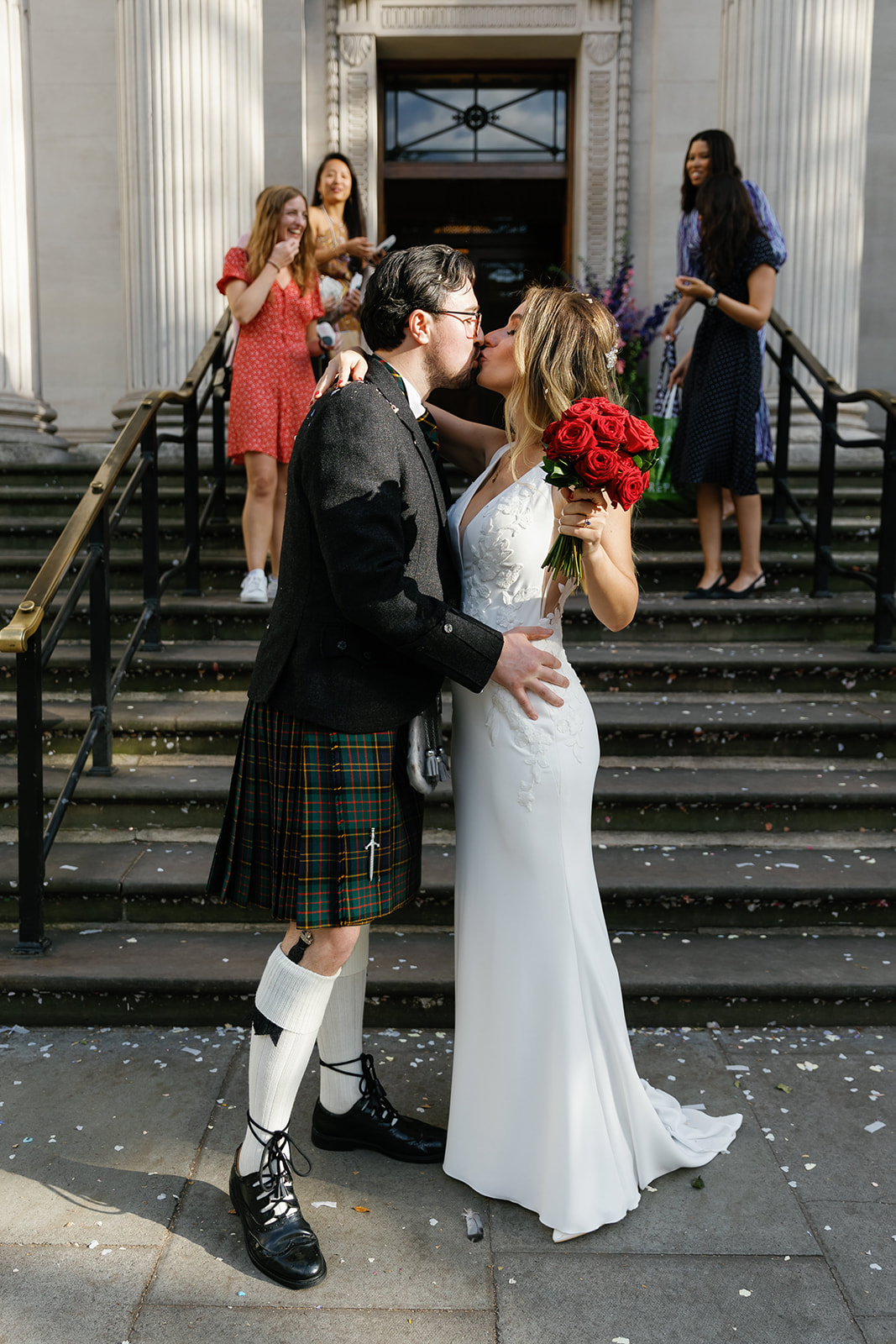 bride and groom kissing outside the hall