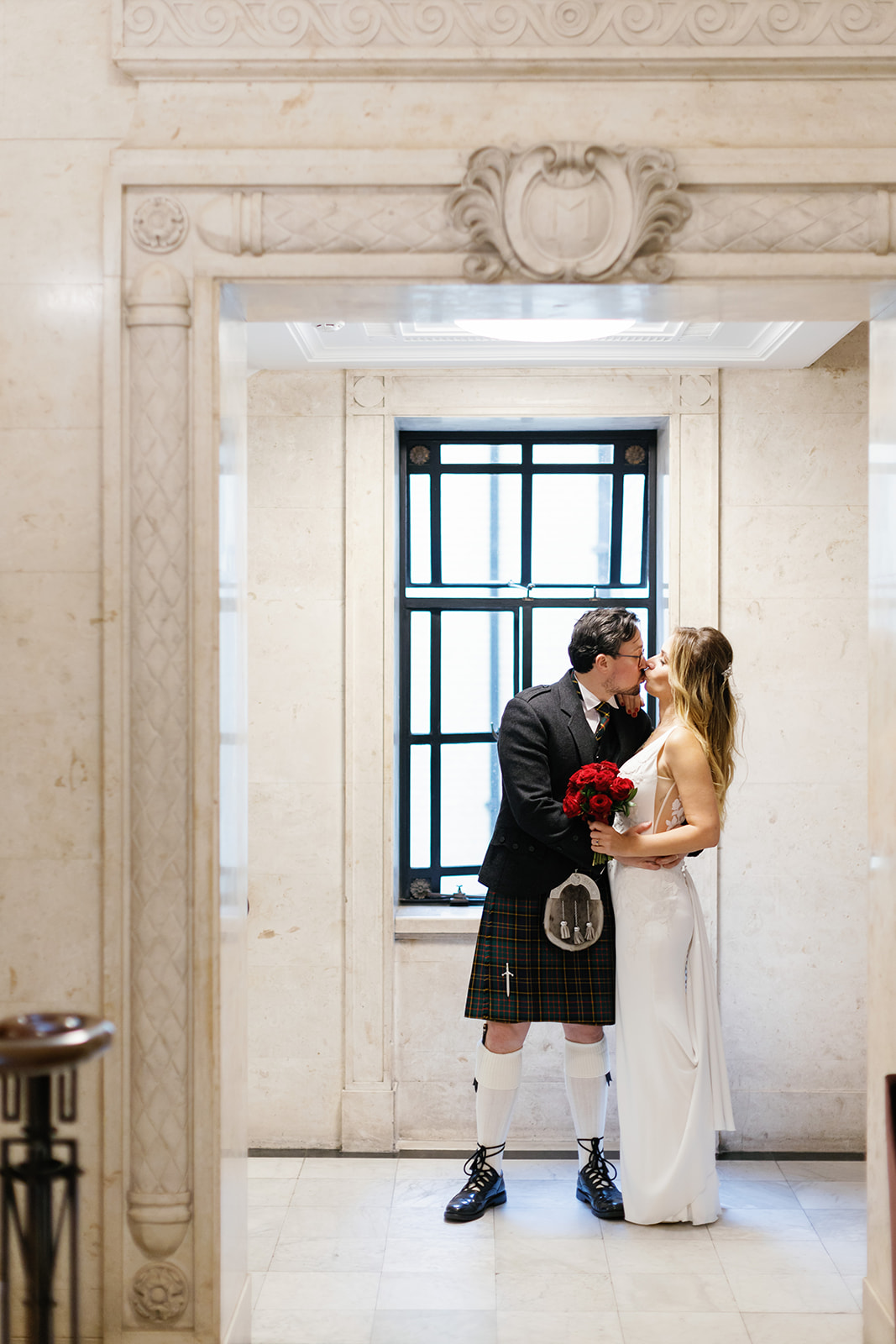 bride and groom kissing in the hallway