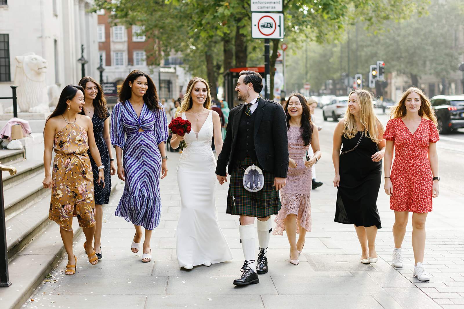 bride and groom walking down the street with guests