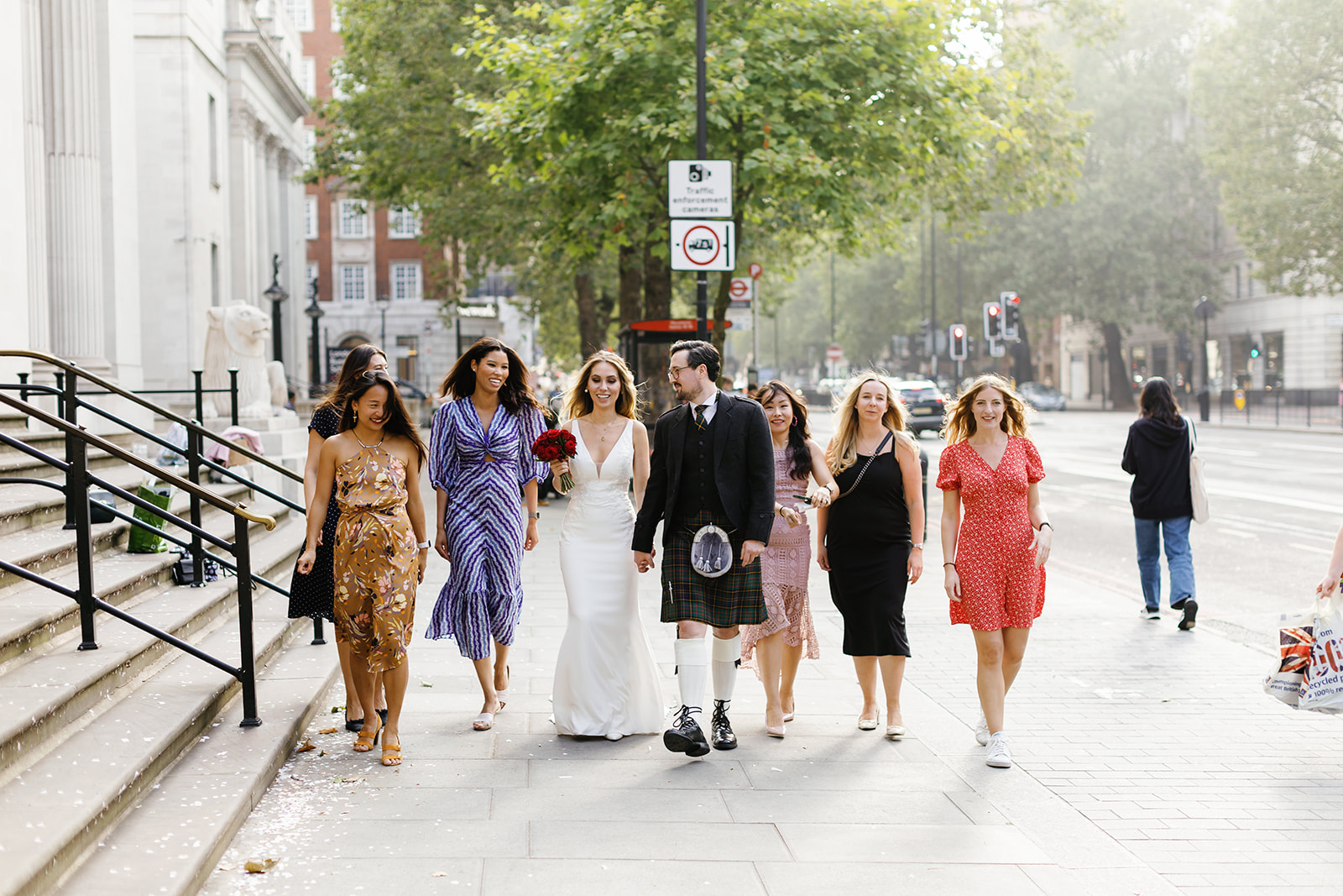 bride and groom walking down the street with guests