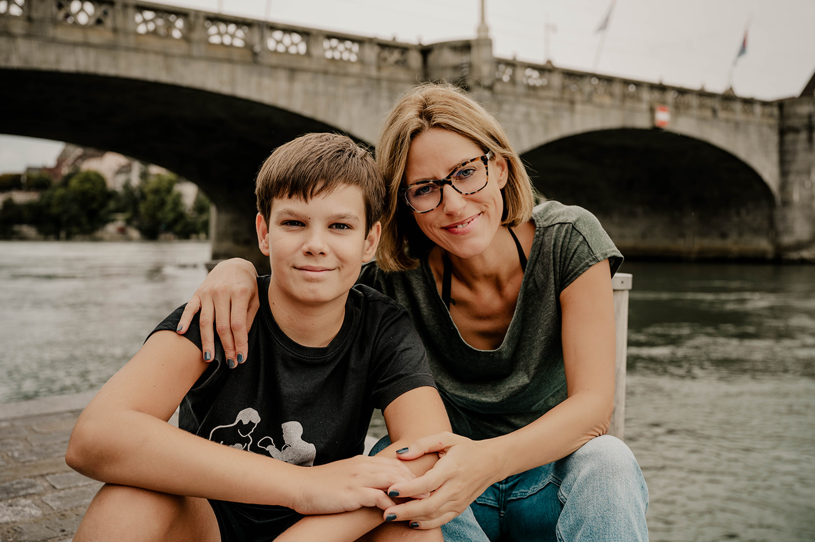 Modern family of mother and son enjoying a family photo session on the Rhein in Basel Switzerland