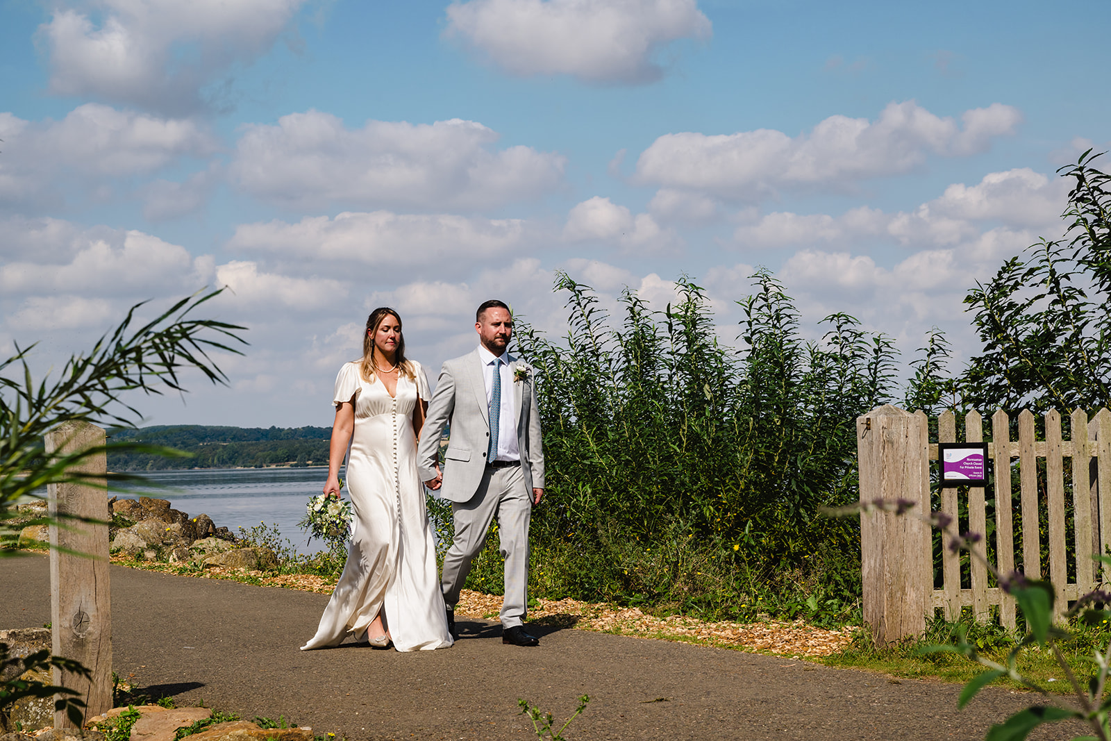 bride and groom walking away from Normanton Church at Rutland water