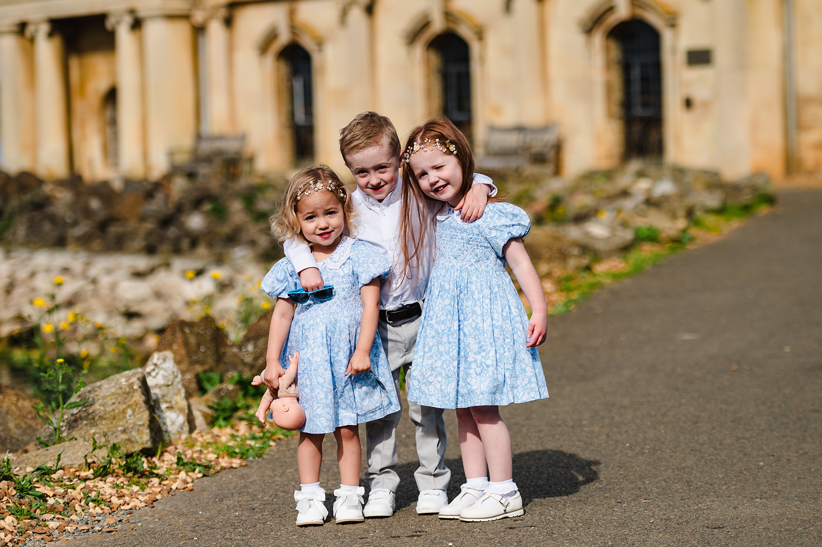 Flower girls and page boy cuddling outside normanton church ahead of their parents wedding