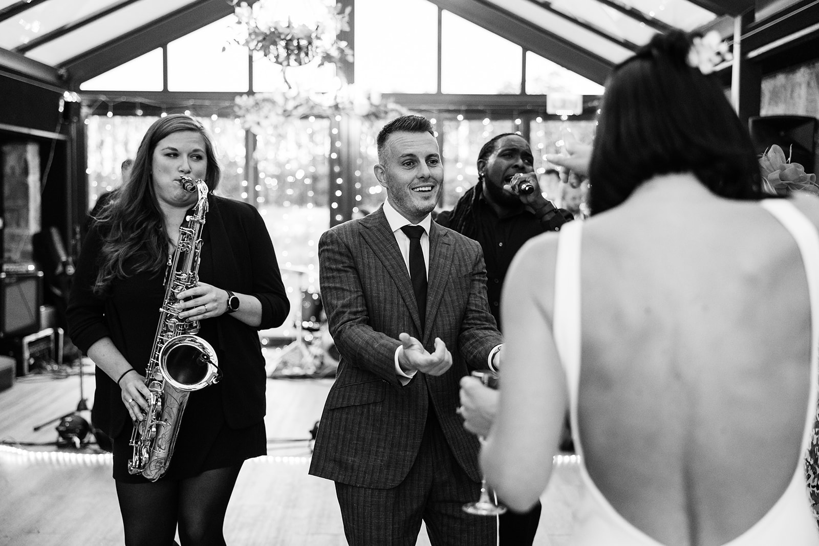 bride and groom dancing as the bands saxophone player plays next to them.