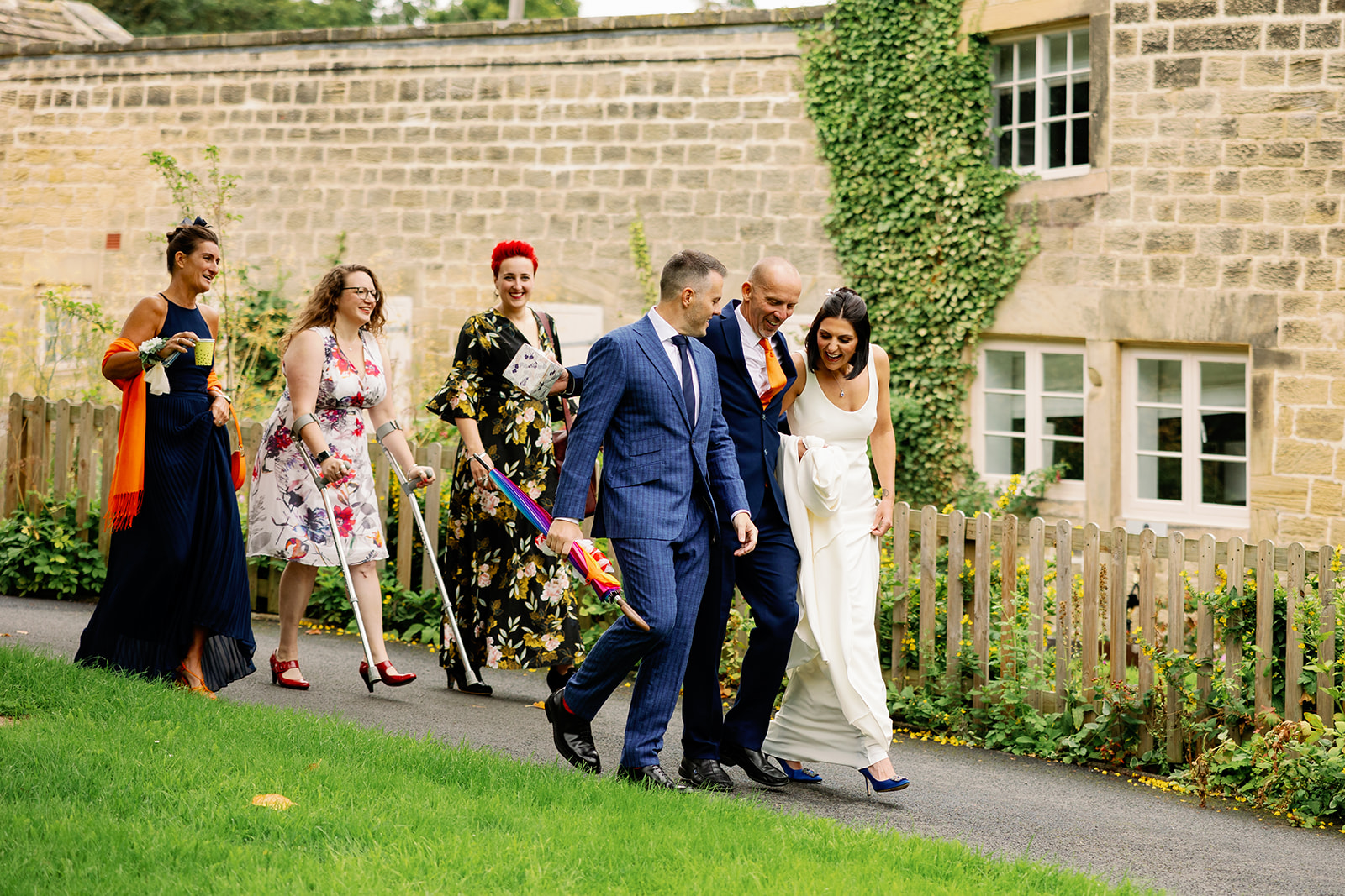 bride and groom and wedding guests walking to their wedding venue