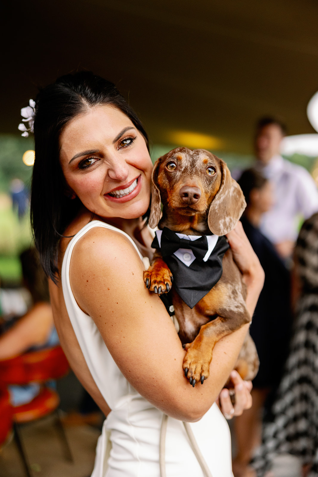 bride posing for a photo with her dachshund