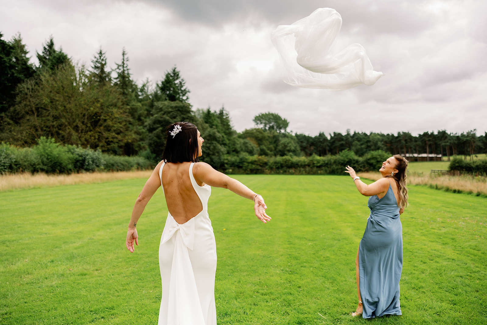 a bride throwing her veil in the air after getting fed up of wearing it
