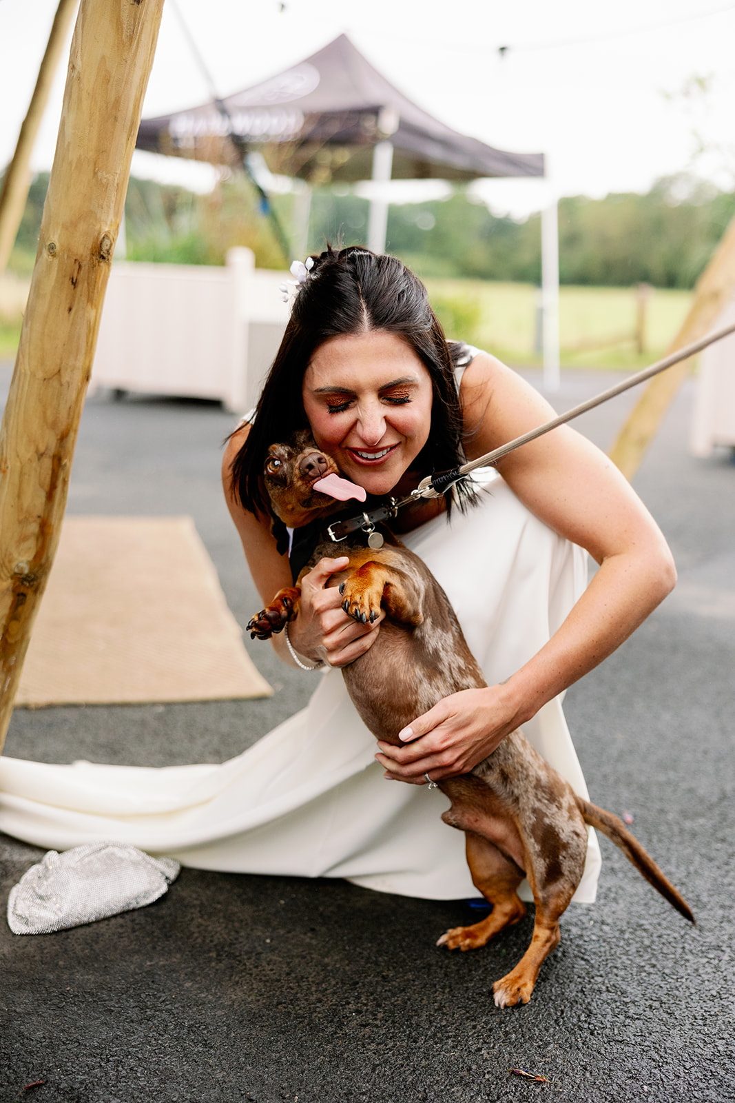 portrait of a bride hugging her pet dachshund at harewod house