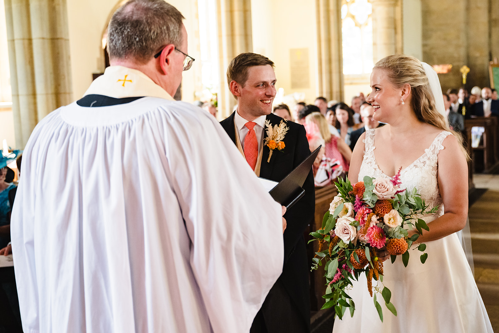 bride and groom looking at each other during wedding ceremony at st peter and st pauls church exton rutland