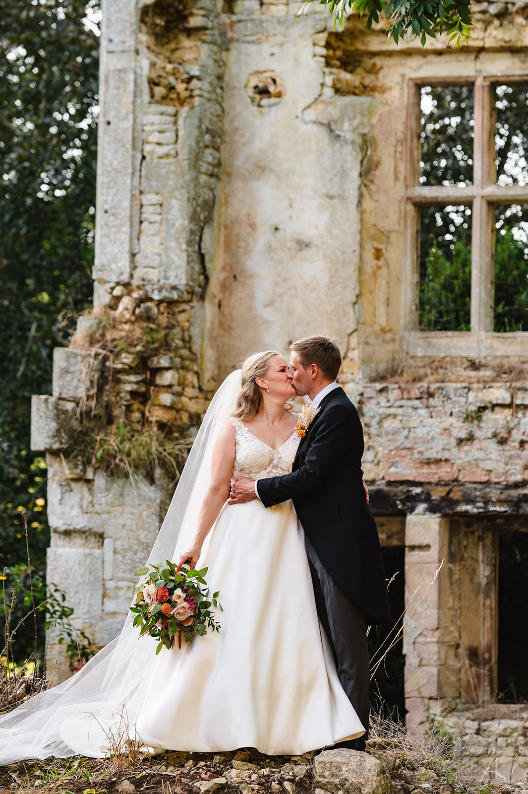 bride and groom portrait of couple kissing in the ruins at exton park rutland