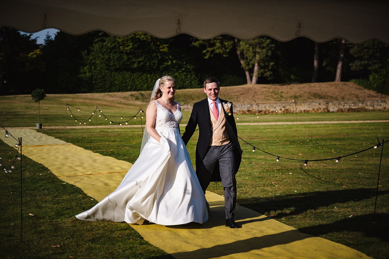 bride and groom walking to their wedding breakfast in exton park in rutland