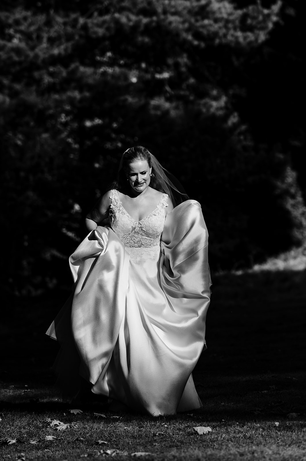 bride holding her dress and walking in the grounds of exton park rutland
