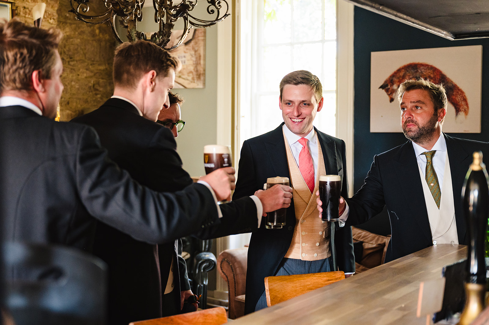 groom and his groomsmen share a pint before the wedding at exton park