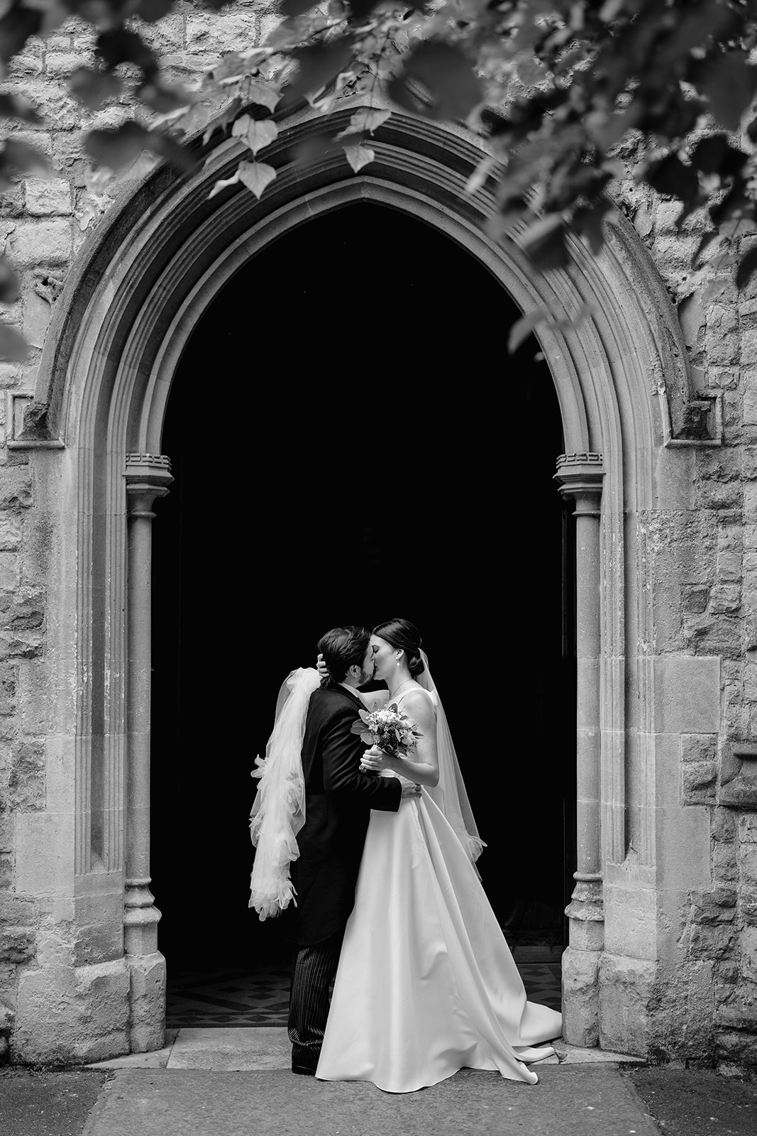 bride and groom kissing at All Saints Church