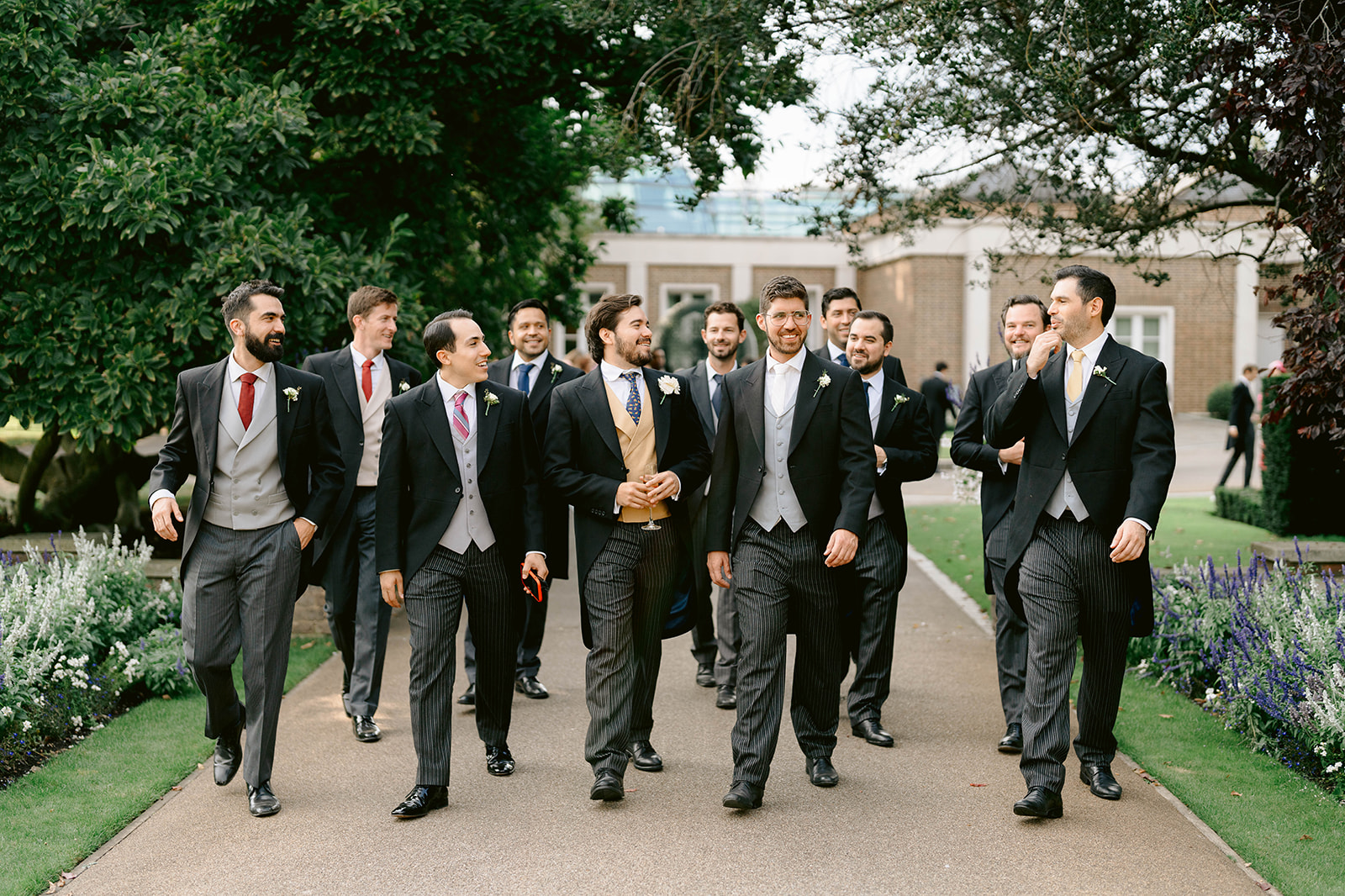 the groomsmen walking through the grounds at the hurlingham club london