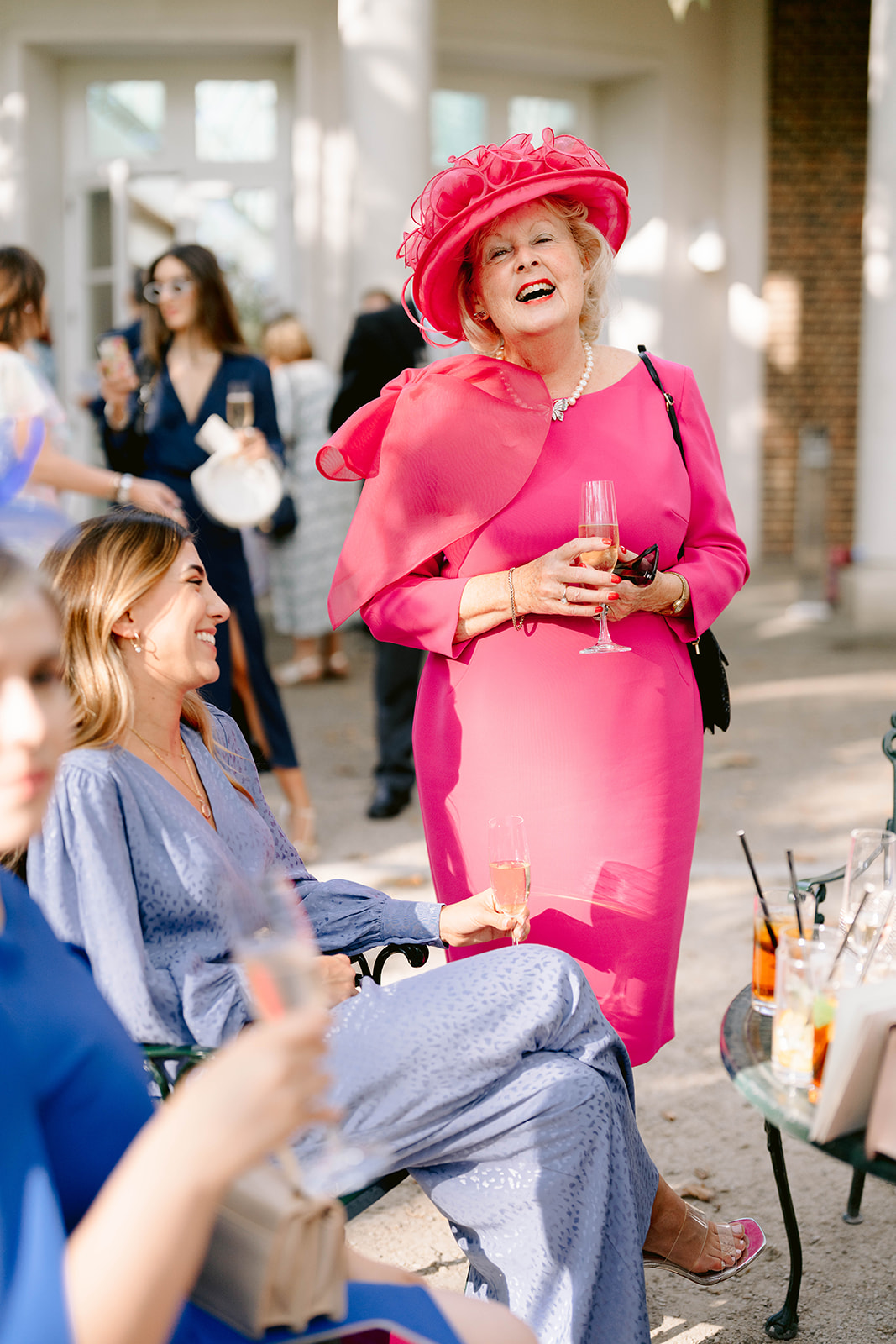 a well dressed wedding guest in pink with a hat