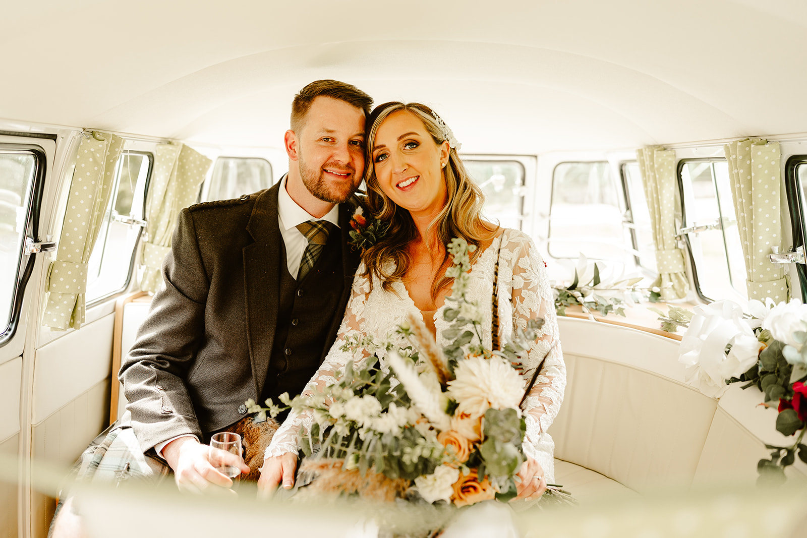 Newlywed couple siting in vintage camper van outside their wedding venue Aswanley