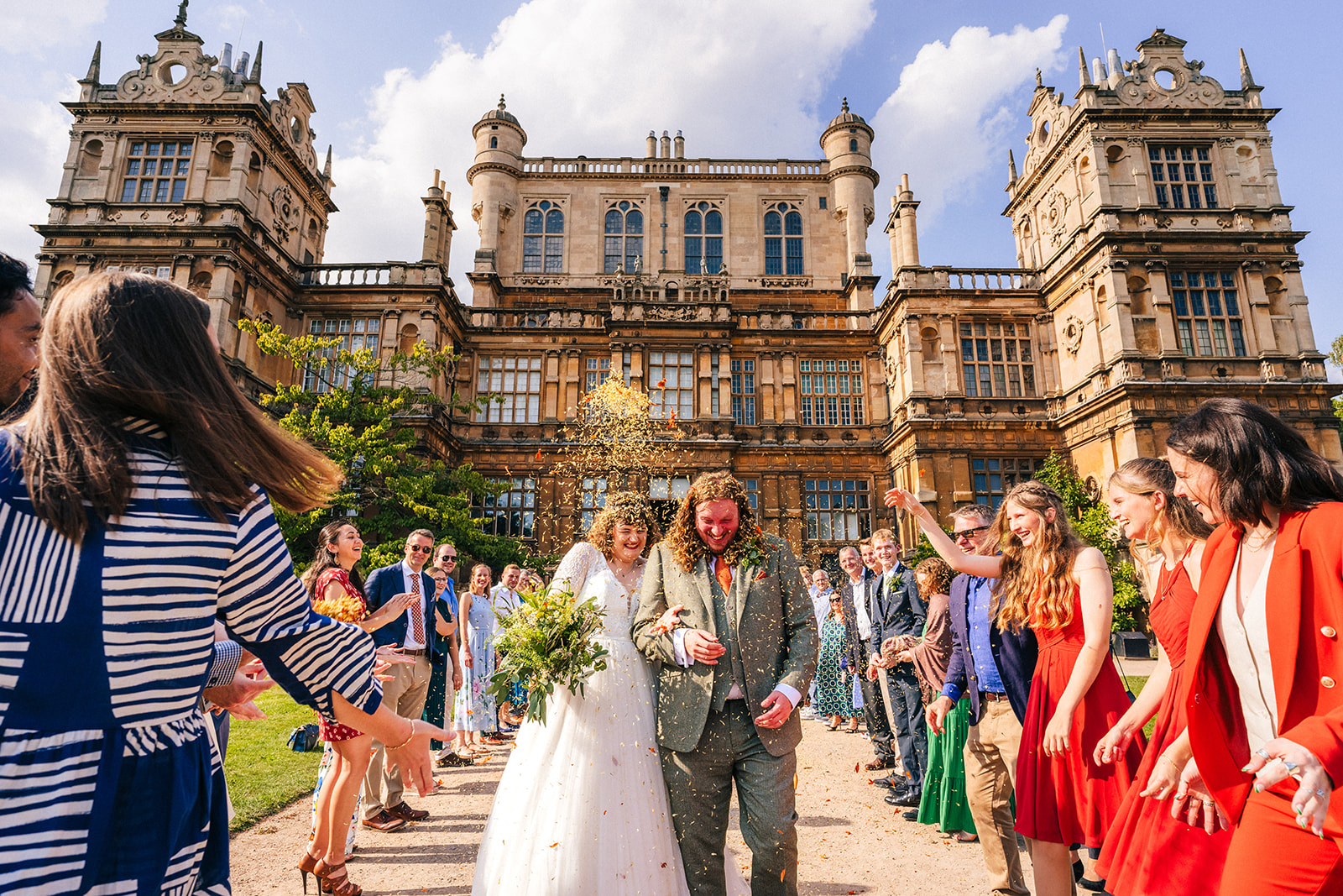 bride and groom getting covered in confetti at Wollaton Hall