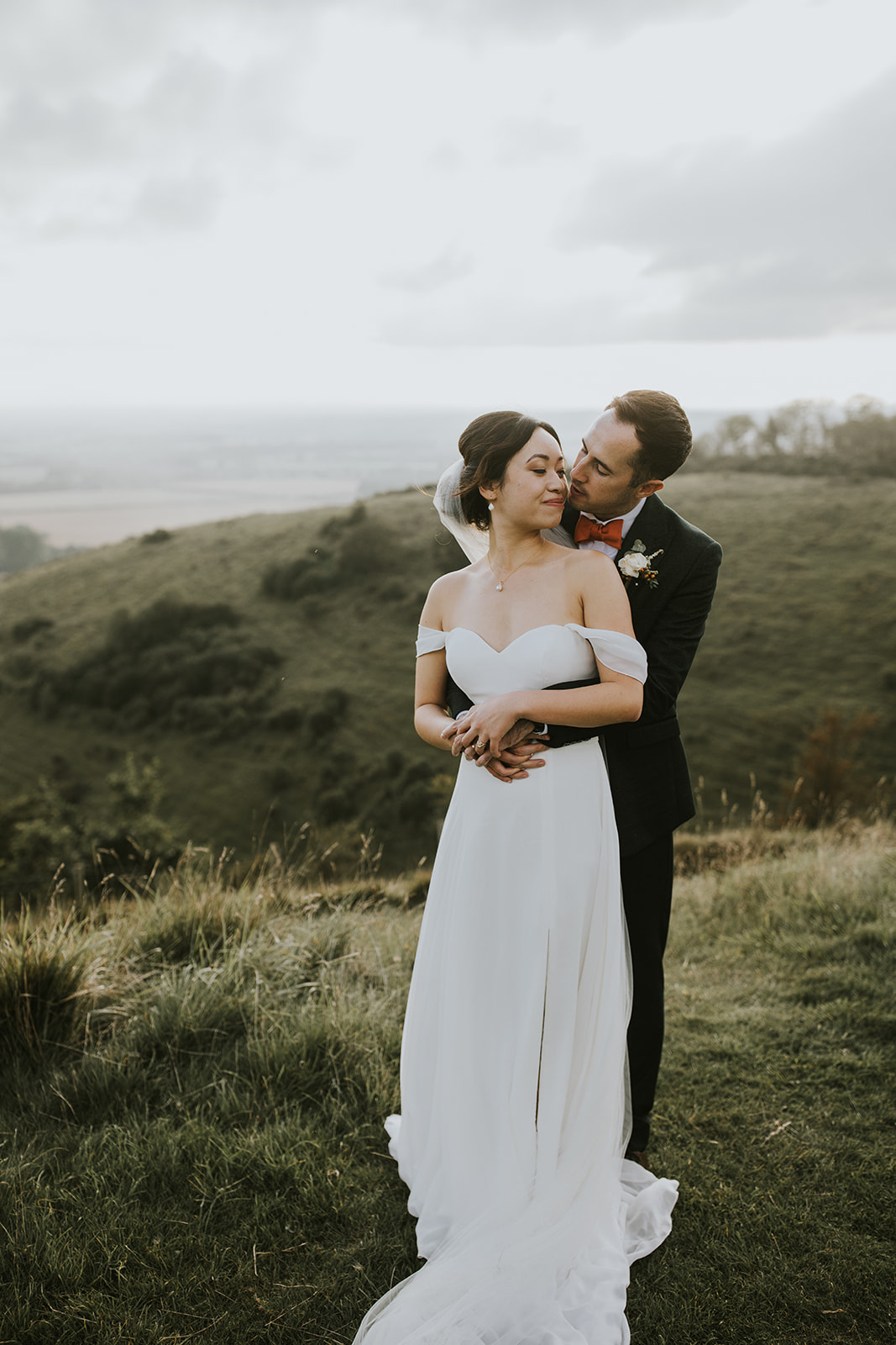 A portrait of the bride and groom on the downs with stunning views as a backdrop