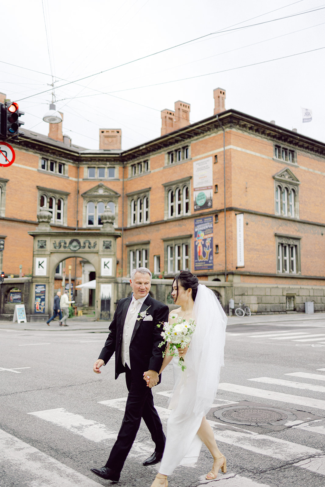 Bride and groom walking to copenhagen city hall to get married in denmark