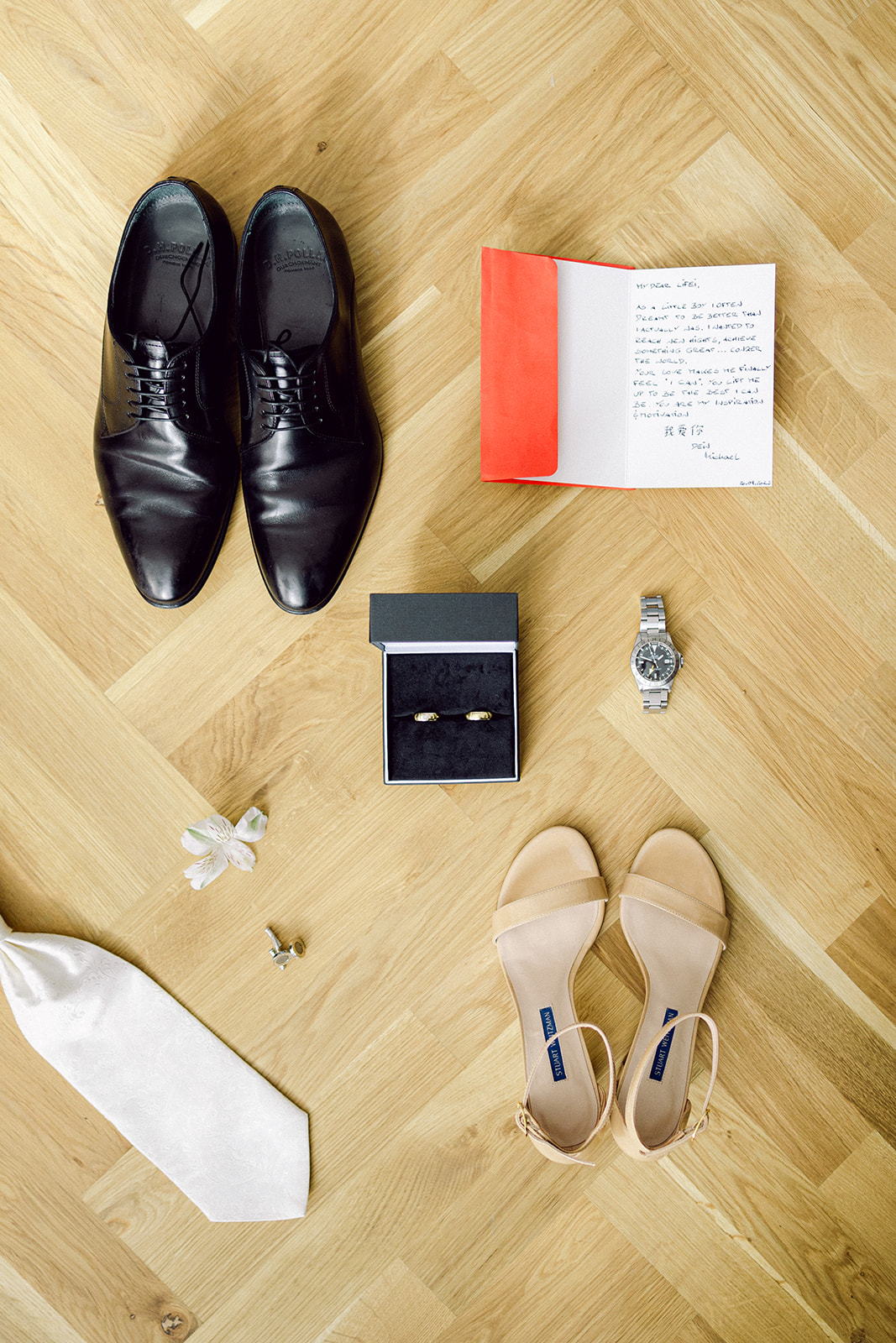 flat lay bride and groom detail stationary rings and shoes