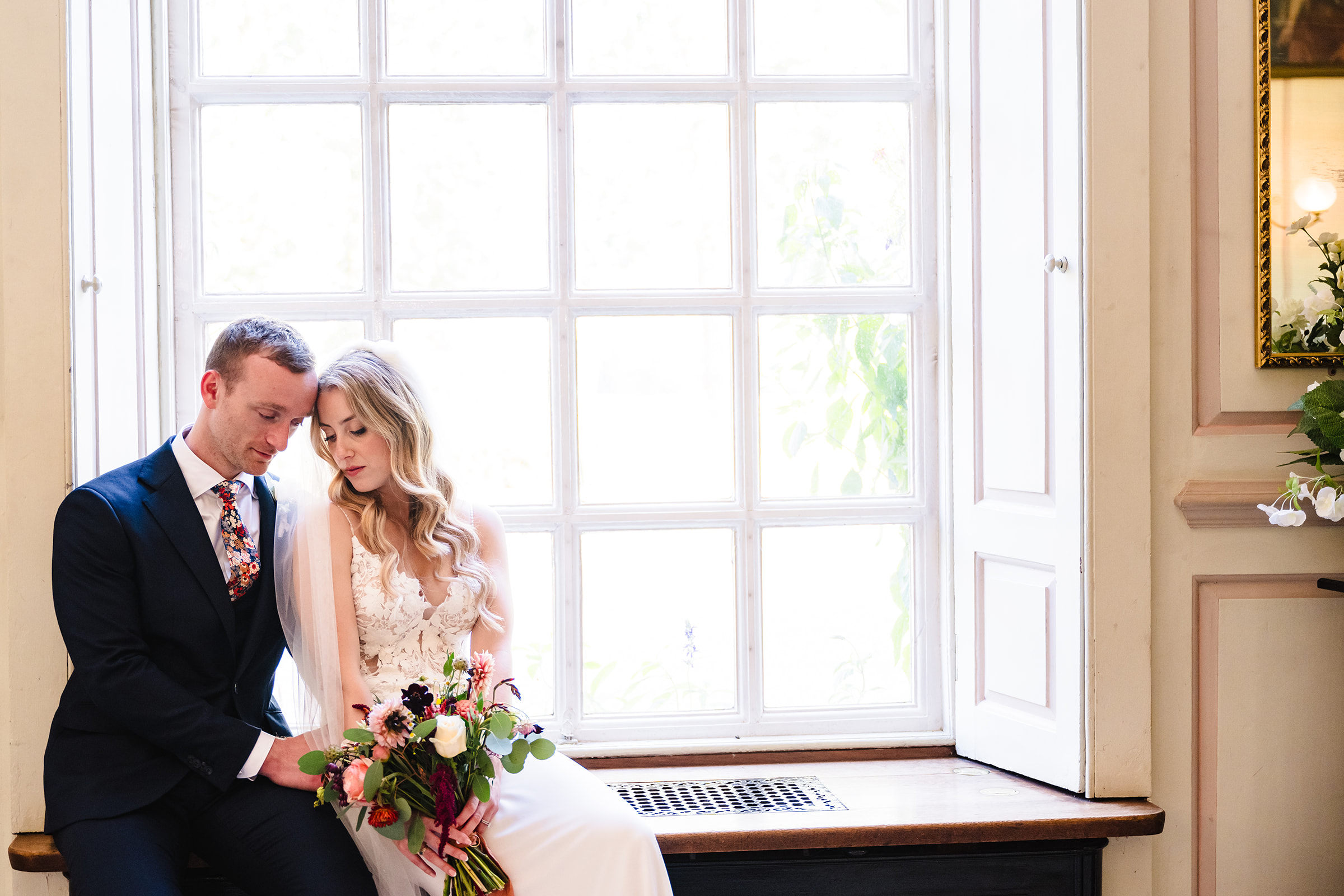 Bride and groom sat in window at gosfield hall