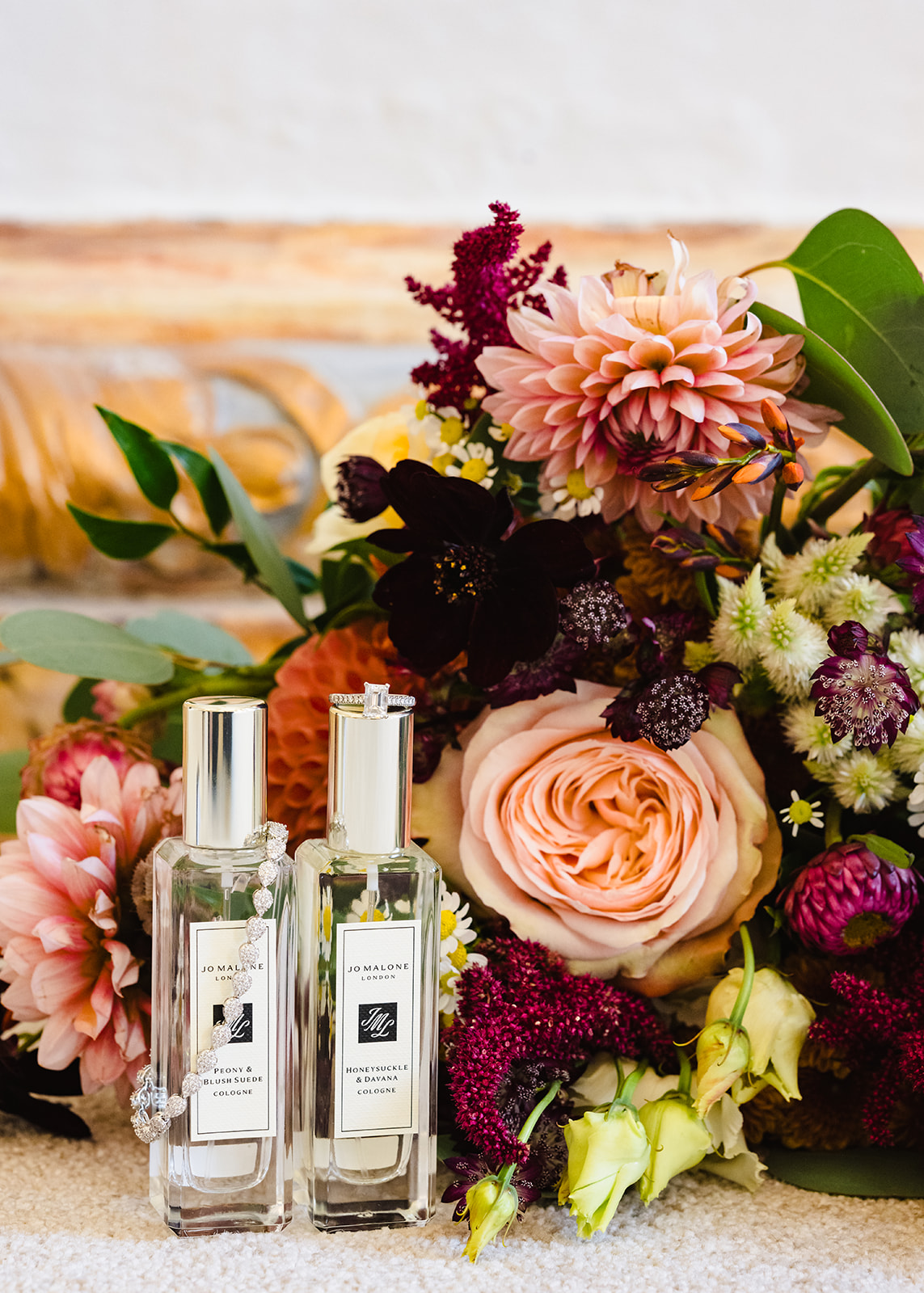 Close up of jo Malone perfume with flowers and wedding jewellery