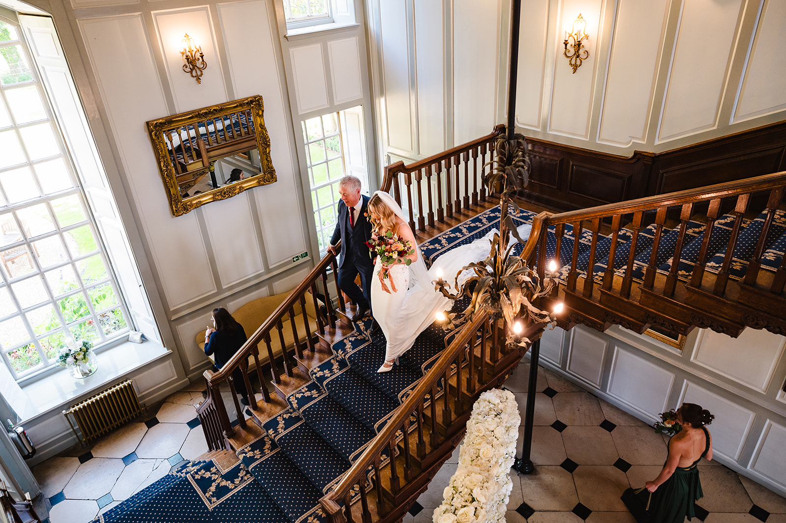 Bride and her dad descending the staircase at gosfield hall