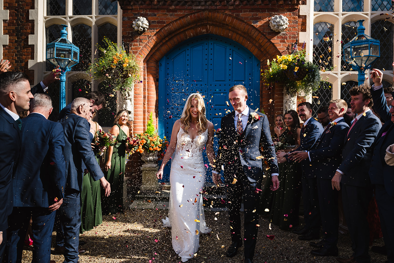 Bride and groom walking through confetti at gosfield hall