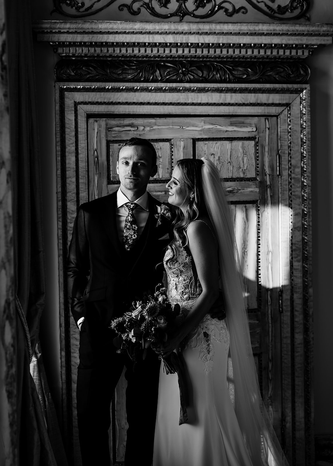Bride and groom portrait stood in window at gosfield hall