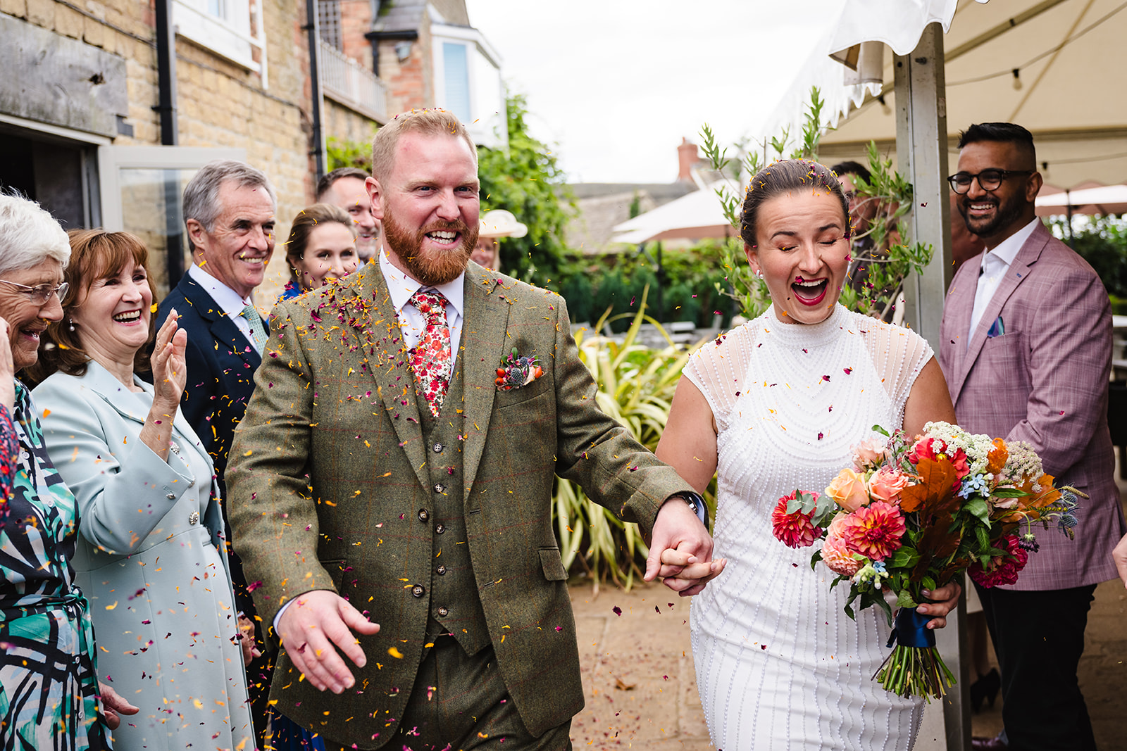Bride and groom walking through confetti at the finches arms hambleton