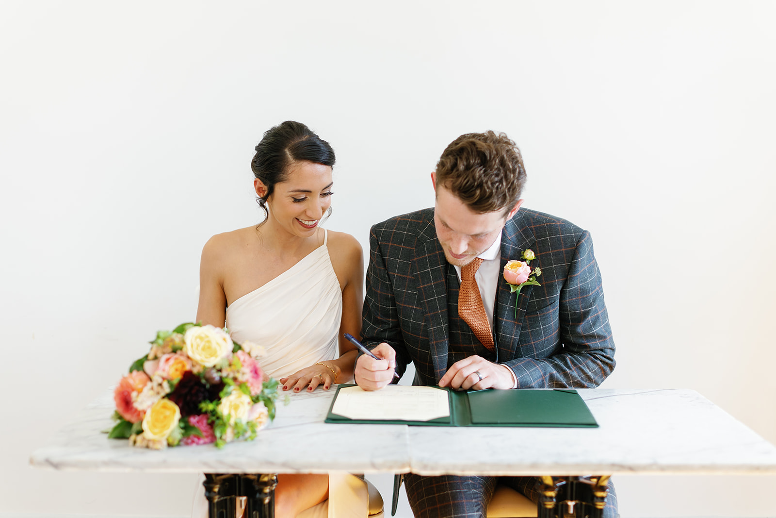 bride and groom signing marriage contract