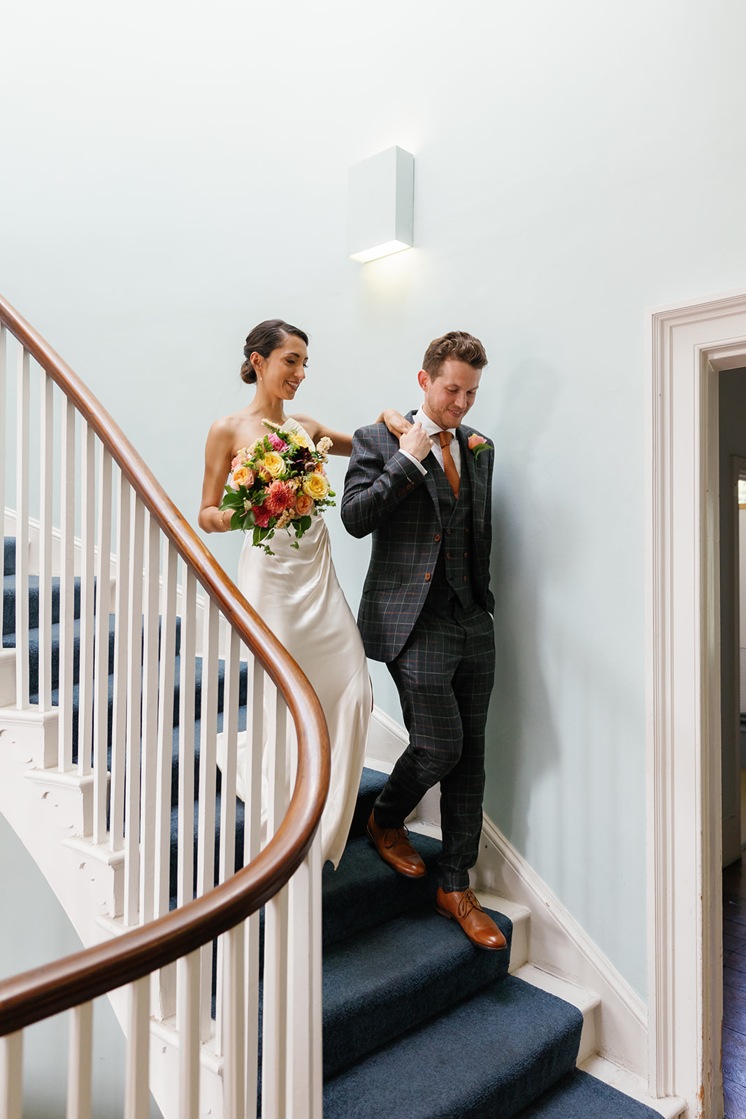 bride and groom walk down the stairs