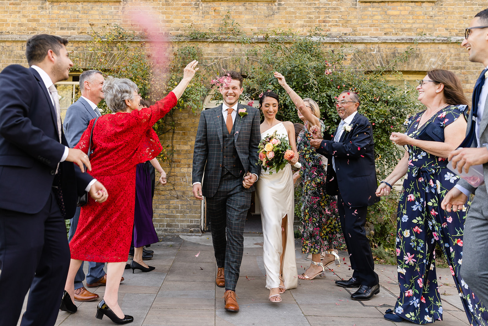 bride and groom welcomed by guest with confetti
