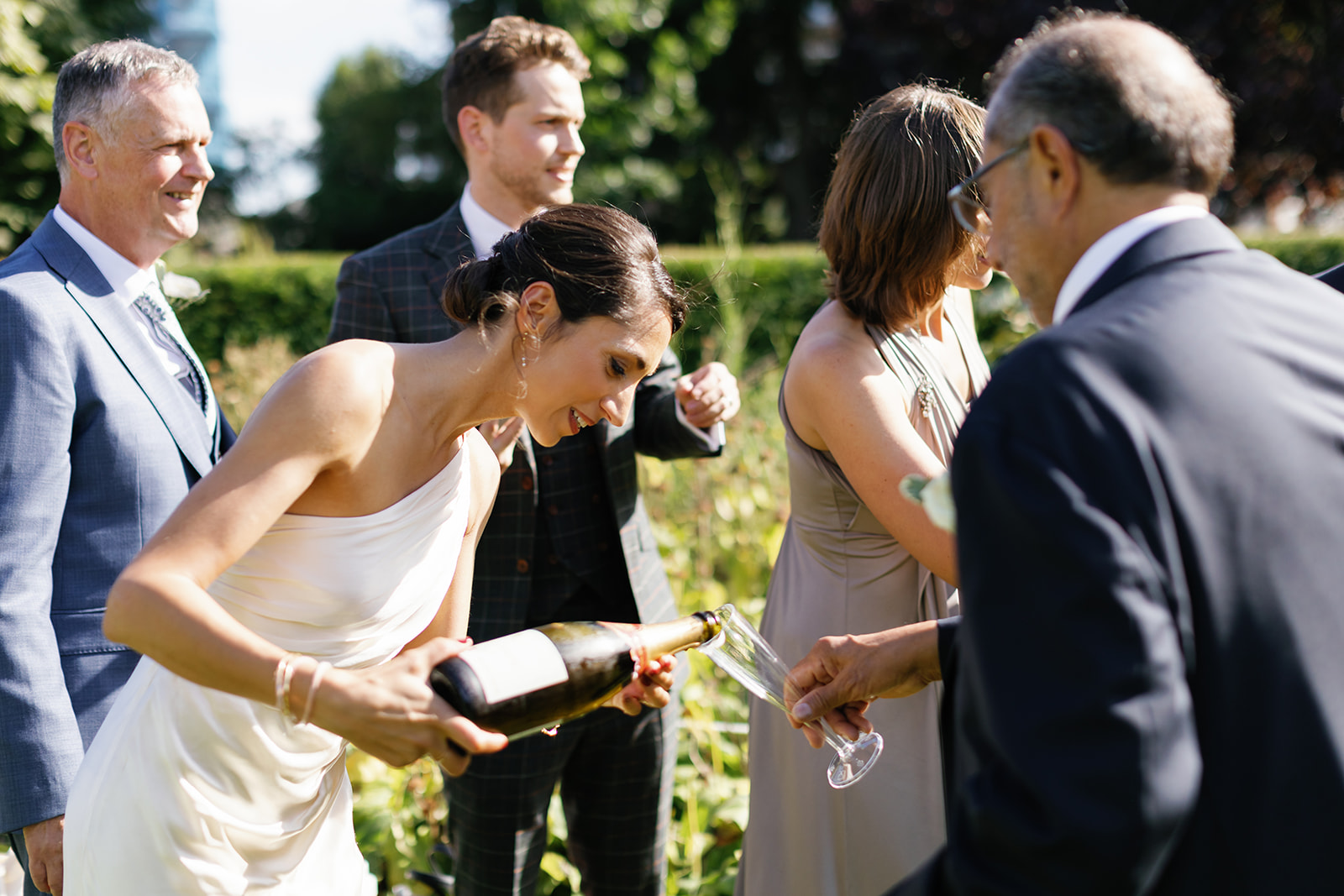 bride pouring wine for the  guests