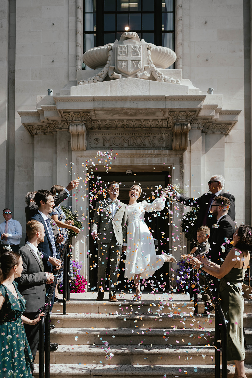 Portrait of Alex and Christina welcomed with confetti toss at Islington Town Hall