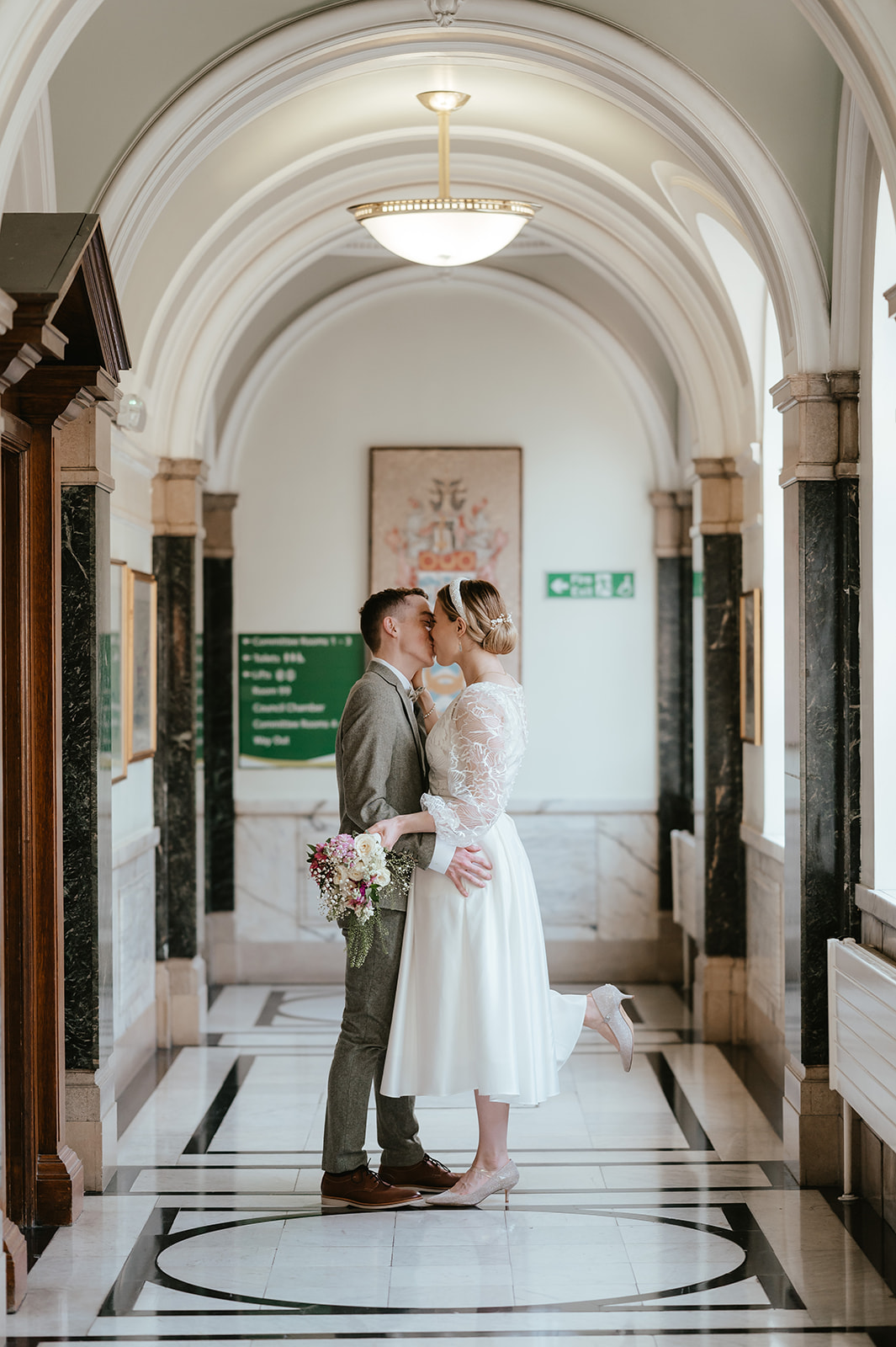 Sweet portrait of Alex and Christina kissing in the hallway at Islington Town Hall