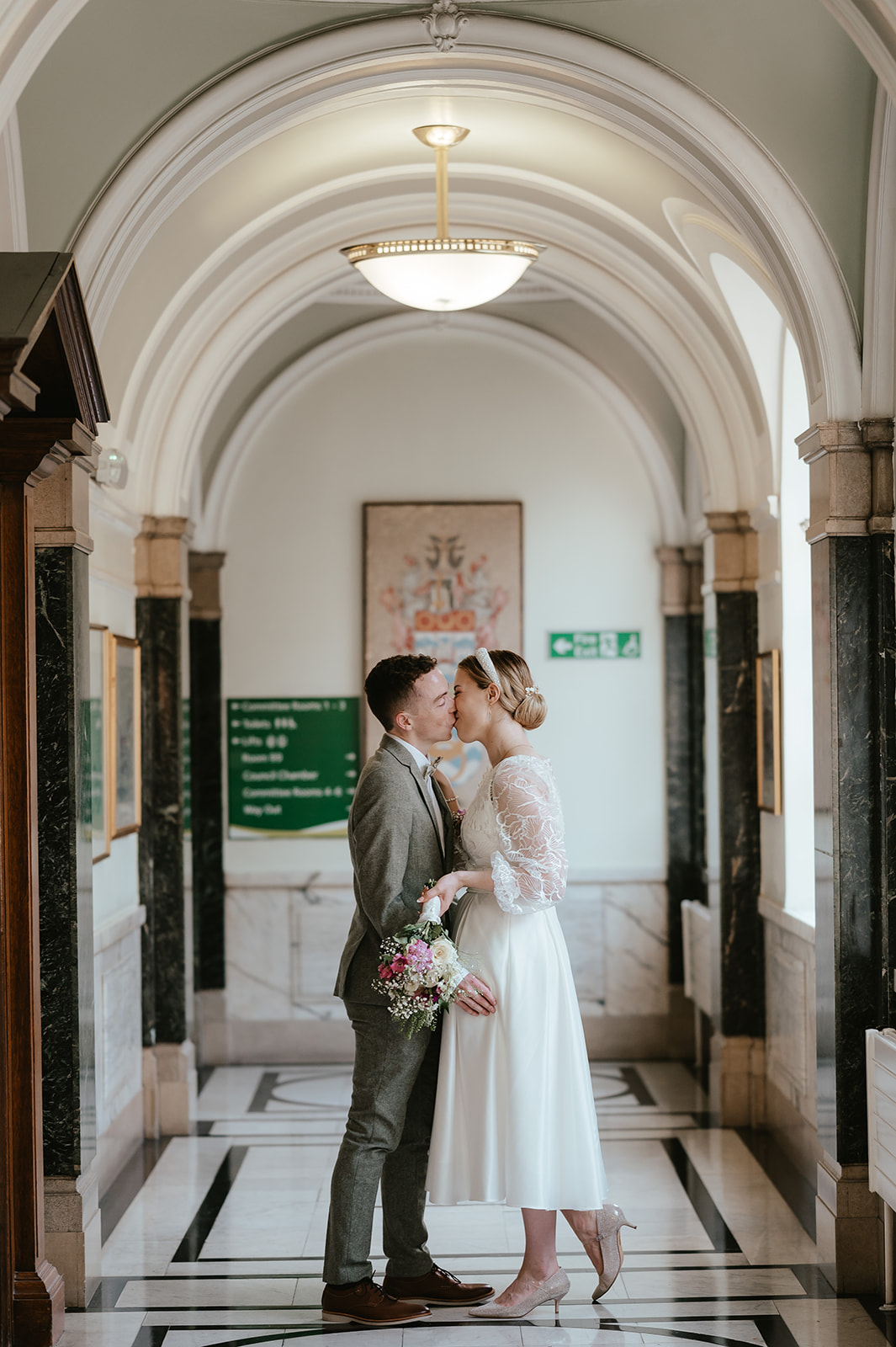 Sweet portrait of Alex and Christina kissing in the hallway at Islington Town Hall