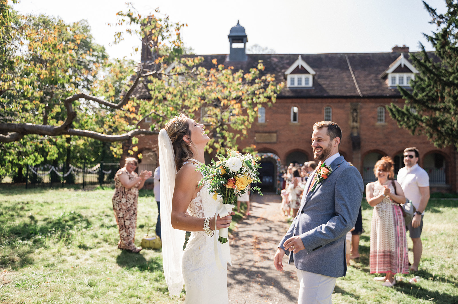 Candid portrait of Natalie and George welcomed with confetti toss at Ashburton Hall